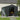 Metal garden storage shed with double doors open, grey corrugated walls, and front latch