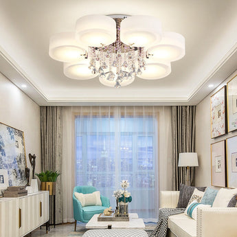 LED semi-recessed ceiling luminaire with multiple round white acrylic shades and hanging crystal
