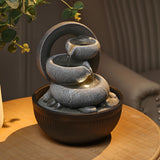 Resin garden fountain with LED glow and small water stream over gray stone feature