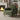 Green chenille armchair with tall back and cushioned seat on dark wooden legs