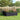 Black raised garden bed planter box with slatted sides and dense flower growth