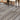 Gray wood-grain vinyl flooring planks with visible plank seams under chair