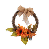 Decorative autumn wreath with orange flowers, greenery, and burlap bow, warm lights