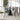 Light gray tufted armless dining chair with padded seat and black metal legs