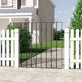 Black metal garden gate with decorative scrollwork and vertical bars