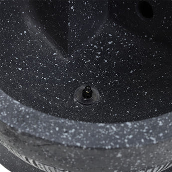 Pump/connector port on gray fountain base with textured stone surface