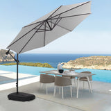 Light grey cantilever parasol open over patio table with dark weighted base