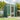 Green metal garden tool storage shed with sloped roof, open side door