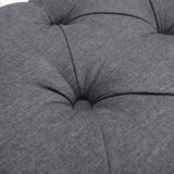 Close-up of tufted seat cushion sections on gray storage bench ottoman