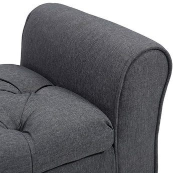 Close-up of gray padded arm and seat cushion on button-tufted storage bench