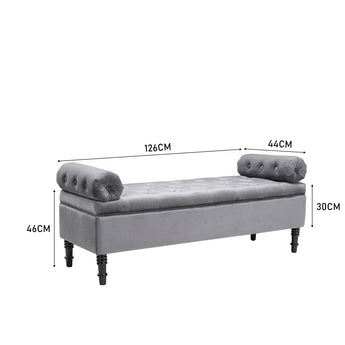 Grey velvet upholstered storage bench with tufted ends and turned wooden legs