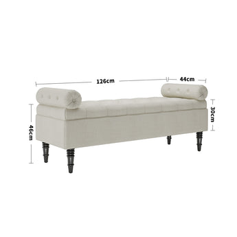 Beige linen upholstered storage bench with tufted ends and dark wooden legs