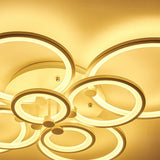 Ceiling-mounted circular LED light with eight ring accents, warm illuminated glow