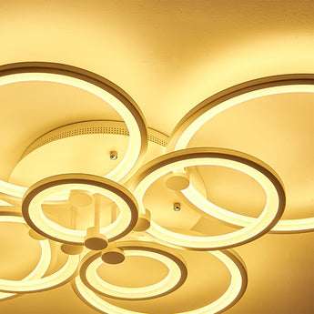 Ceiling-mounted circular LED light with eight ring accents, warm illuminated glow